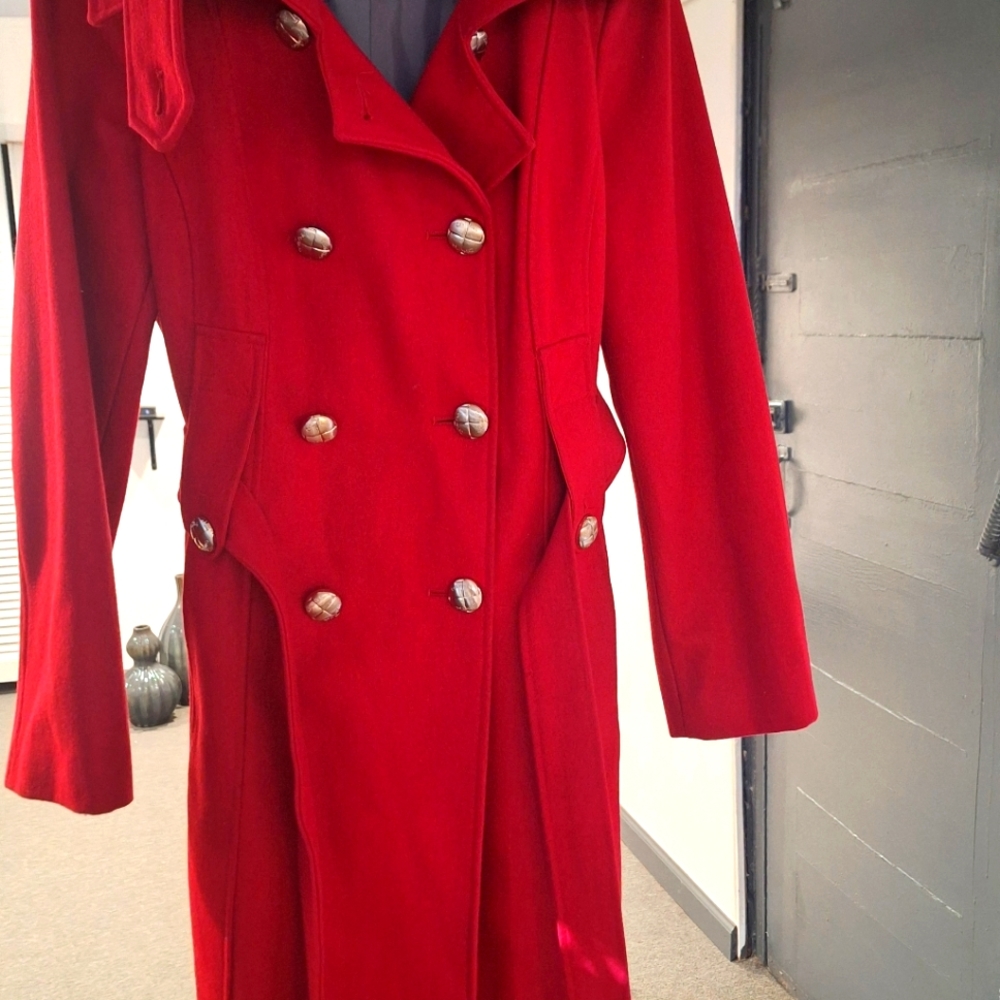Womens red coat with gold metal buttons with pull up collar and belt.